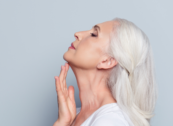 woman raising head by lifting neck with hand