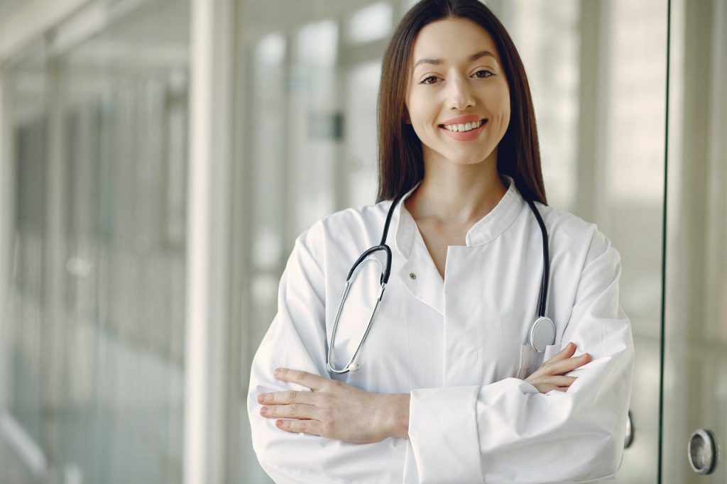 surgeon standing with arms folded and smiling at camera